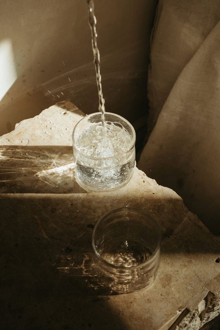 Agua vertiéndose en un vaso sobre piedra